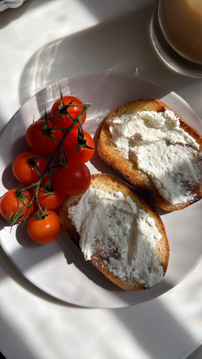 Two slices of gluten-free sourdough toast with cream cheese and vine tomatoes